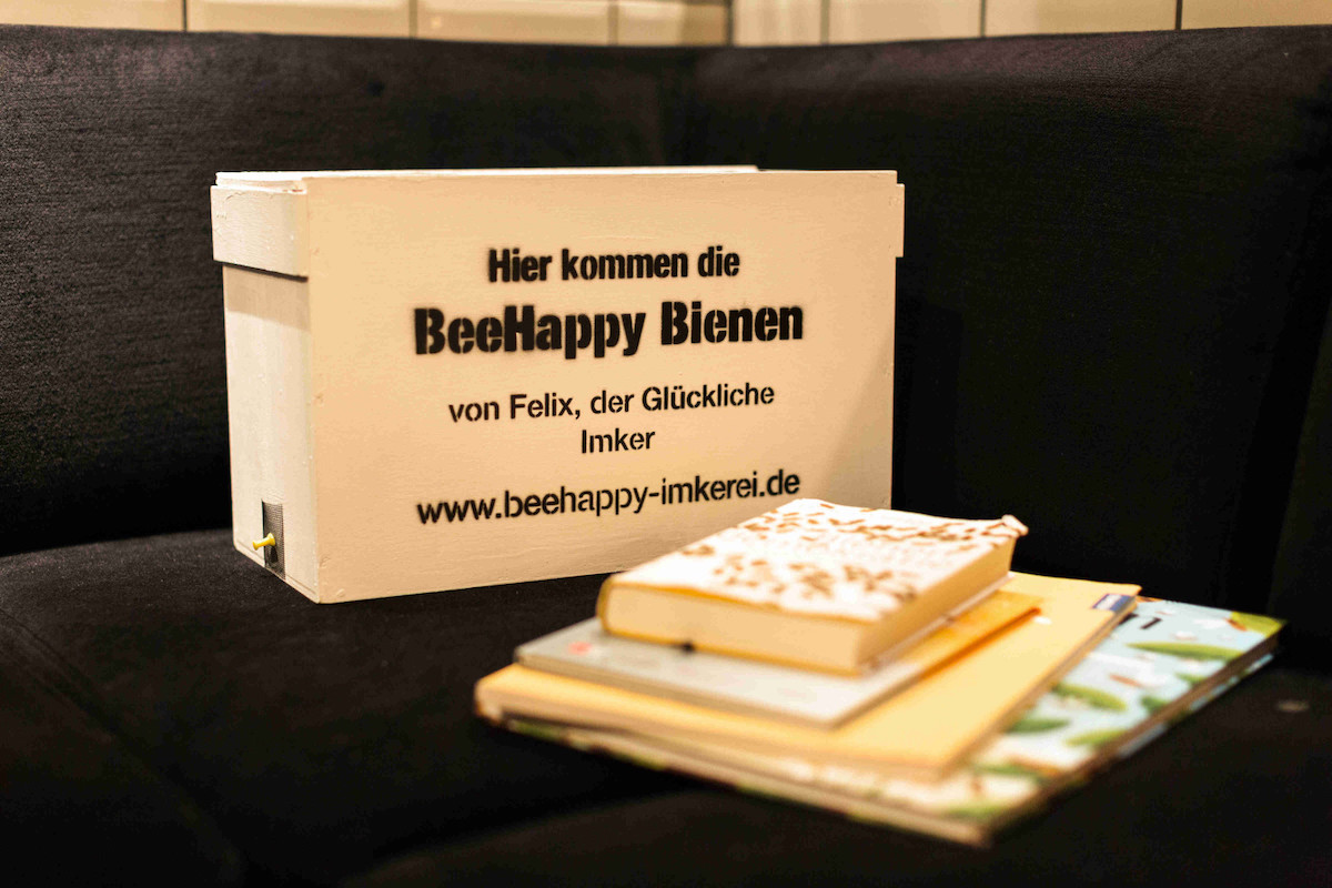 Die BeeHappy Bienenbox steht vor Bienenbüchern